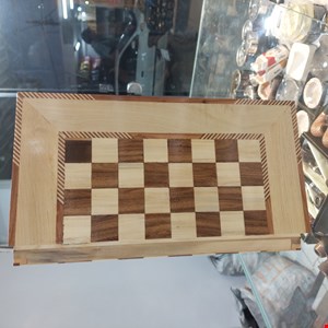  این تخته نرد زیبا با هنر اصیل معرق‌کاری دست‌ساز ساخته شده و جلوه‌ای چشم‌نواز از ترکیب چوب‌های طبیعی را به نمایش می‌گذارد. طراحی ستاره هشت‌پر در مرکز صفحه، همراه با رگه‌های طبیعی چوب و پرداخت براق، این محصول را به اثری هنری و کاربردی تبدیل کرده است.استفاده از چوب باکیفیت، ظرافت در اجرای معرق و دقت در جزئیات ساخت، باعث شده این تخته نرد علاوه بر مناسب بودن برای بازی، گزینه‌ای ارزشمند برای هدیه و دکوراسیون نیز باشد. هر قطعه به دلیل ماهیت طبیعی چوب و اجرای دستی، دارای ویژگی‌های منحصربه‌فرد است و ارزش هنری خاص خود را دارد.ویژگی‌ها:معرق‌کاری کاملاً دست‌سازساخته‌شده از چوب طبیعیطراحی سنتی و چشم‌نوازپرداخت و پوشش براق و مقاوممناسب برای بازی، کلکسیون و هدیهمحصولی خاص با اصالت هنر ایرانیاین تخته نرد انتخابی ایده‌آل برای علاقه‌مندان به صنایع‌دستی، هنر چوب و بازی‌های فکری سنتی است.